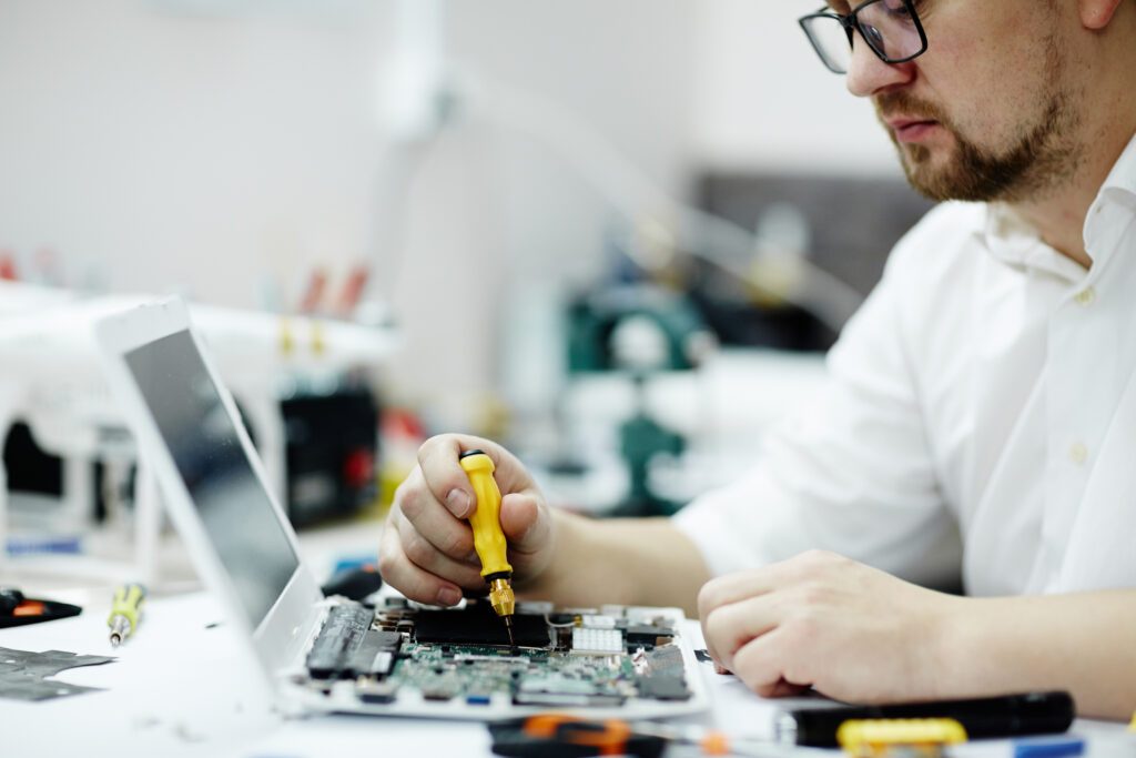 homem reparando placa mae notebook